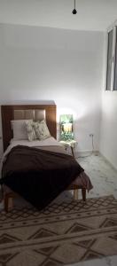 a bedroom with a large bed and a chair at Chambre single in Tunis