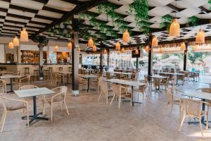 a dining room with tables and chairs and lights at Makronisos Village in Ayia Napa