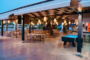 a restaurant with tables and a ping pong table at Makronisos Village in Ayia Napa