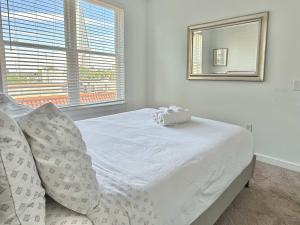 ein weißes Bett in einem Zimmer mit einem Spiegel in der Unterkunft Luxury New 2B2B Private Balcony 542Blvd in Atlanta