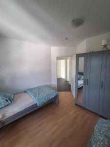 een slaapkamer met een bed, een kast en een spiegel bij BJM Comfort Apartments Oberursel in Weißkirchen +8 foto's