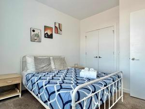 ein Schlafzimmer mit einem Bett mit einer blau-weißen Bettdecke in der Unterkunft Luxury New 2B2B Private Balcony 542Blvd in Atlanta