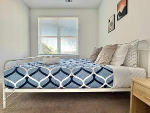 ein Schlafzimmer mit einem Bett mit einer blau-weißen Bettdecke in der Unterkunft Luxury New 2B2B Private Balcony 542Blvd in Atlanta + 11 Fotos