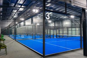 Una gran cancha de tenis con pisos y ventanas azules. en Villae Verdasca, en Palmeira
