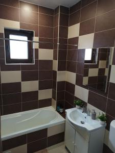 a bathroom with a tub and a sink and a bath tubermottermott at Apartament Royal in Şelimbăr +4 photos