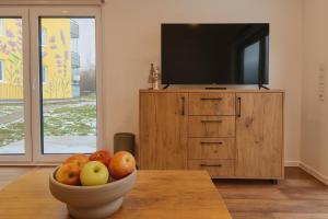 un cesto di frutta su un tavolo di fronte a una TV di Tiny House - Gemütlich, ruhig, privat - mit Parkplatz und Terrasse a Lichtenau