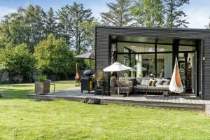 Vejby StrandIndulgence In Architect-Designed House In Vejby的黑色棚子,配有沙发和雨伞 更多25张照片