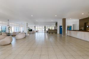 a large lobby with couches and tables in a building at Makronisos Village in Ayia Napa