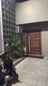 a motorcycle parked in front of a building with a door at Quarto in São Francisco do Sul