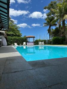 uma piscina com cadeiras e um gazebo em Samba Angra dos Reis em Angra dos Reis