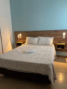 a bedroom with a bed with a white comforter at Exito in Guarulhos