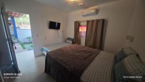a bedroom with two beds and a tv and a window at Casa Bananeiras Azul in Bananeiras