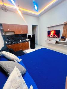 a bedroom with a blue bed and a kitchen at Exclusive and Central Studio Apartment in Trinidad