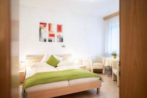 a bedroom with a bed with a green blanket at Hotel-Café-Restaurant Matzelsdorfer Hof in Millstatt