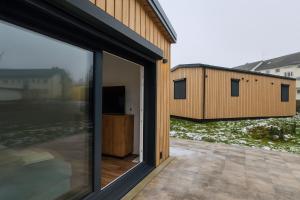 una vista esterna di una casa con una porta scorrevole in vetro di Tiny House - Gemütlich, ruhig, privat - mit Parkplatz und Terrasse a Lichtenau