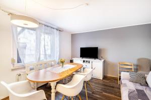una sala da pranzo con tavolo, sedie e divano di Ferienhaus im Harz a Harzgerode