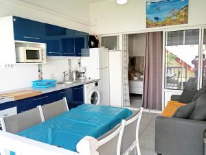 a kitchen with blue cabinets and a table in a kitchen at Bluehibiscus in Saint-François