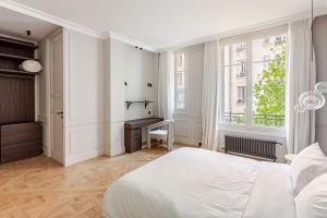 una camera da letto bianca con un letto e una scrivania di Luxury Apartments entirely next to the Eiffel Tower - Paris a Parigi