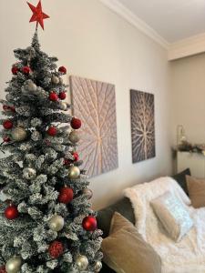 a christmas tree with red and silver decorations in a living room at Psimithefto Luxury Apartments in Thessaloniki