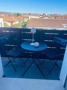 a table on a balcony with a lamp and chairs at Treviso Home Chic in Treviso