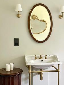 Un baño con un lavabo y un espejo en la pared. en The Green, en Wingfield