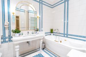 um banheiro com piso de azulejos azuis e brancos, banheira e pia em Hotel Ristorante Ala d'Oro em Lugo mais 133 fotografias