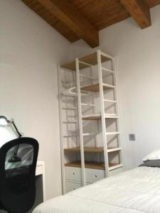 a bedroom with a white book shelf next to a bed at ÁTICO ACOGEDOR LUJOSO CHECK-IN 24H PENTHOUSE 5 Planta 5 in Zaragoza