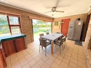 克尼斯纳Brenton Park Cottage 15的配有桌椅和冰箱的厨房