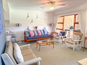 克尼斯纳Brenton Park Cottage 15的客厅里有一张蓝色的沙发和椅子