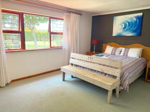 克尼斯纳Brenton Park Cottage 15的一间卧室配有一张床、一张长凳和一个窗户。 更多29张照片