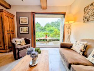 a living room with a couch and a table at Domaine le Puits de Jeanne in Plouégat-Moysan