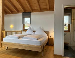 a bedroom with a bed with white sheets and pillows at Ferienwohnung Richter in Rettenberg