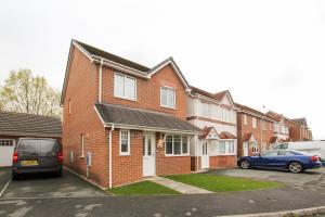 a red brick house with a van parked in a parking lot at Modern 3-Bedroom Home in Quiet Cul-de-Sac w Parking by Rework Accommodation in Saltney