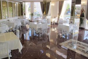 a dining room with white tables and white chairs at Kaya Palas Hotel in Kırklareli