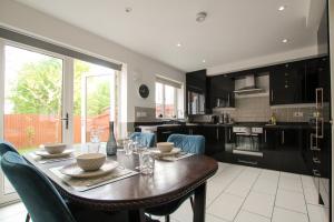 a kitchen with a wooden table and blue chairs at Modern 3-Bedroom Home in Quiet Cul-de-Sac w Parking by Rework Accommodation in Saltney