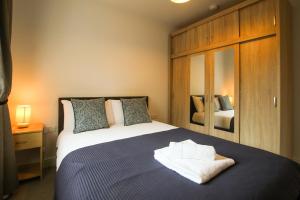 a bedroom with a king sized bed with a mirror at Modern 3-Bedroom Home in Quiet Cul-de-Sac w Parking by Rework Accommodation in Saltney