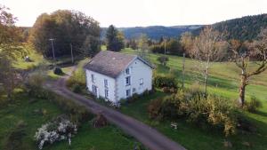 an aerial view of a white house in a field at Le Repaire de la Chouette in Girmont-Val-dʼAjol