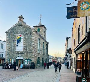a group of people walking down a street in front of a building at Fitz House in Keswick