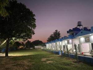 a row of buildings with a tree in a field at Pushkar Prime Resort in Pushkar +20 photos