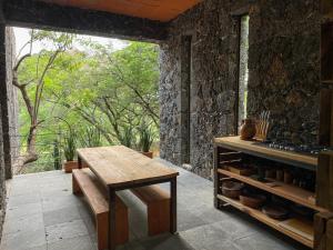 una cucina con un tavolo, un bancone e una finestra di El Sereno Amatlán, Tepoztlán a Amatlán