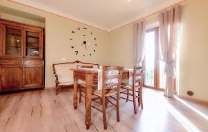 a dining room with a table and a clock on the wall at Pet Friendly Home In Pescina in Tepolini