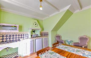 a kitchen with a table and a clock on the wall at Pet Friendly Home In Pescina in Tepolini