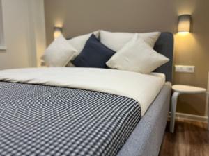 Lumio Apartment 1 في كارلسروه: سرير عليه وسائد زرقاء وبيضاء