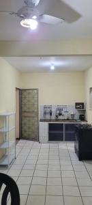 a large room with a kitchen with a counter at Casa 2 quartos com ar condicionado e próximo ao centro in Cachoeiro de Itapemirim