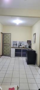 a large kitchen with a large white tile floor at Casa 2 quartos com ar condicionado e próximo ao centro in Cachoeiro de Itapemirim +13 photos