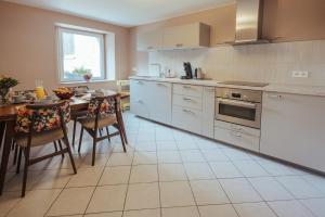 a kitchen with white appliances and a table with chairs at Im Prummehuck in Raeren