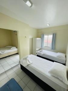 a hotel room with two beds and a window at Hotel Transbrasil in Belém