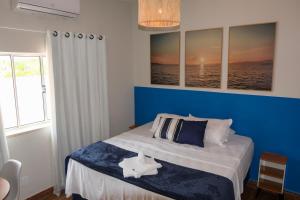 a bedroom with a bed with a blue wall at Barra Comfort Pousada in Salvador