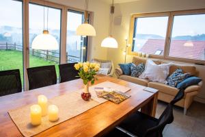 a living room with a wooden table with flowers on it at Ferienwohnung Weitblick im Dahner Felsenland in Bruchweiler-Bärenbach
