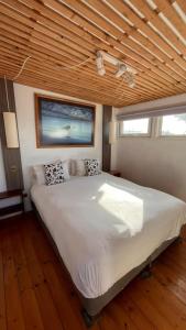 un letto grande in una stanza con soffitto in legno di El Crucero Pichilemu a Pichilemu